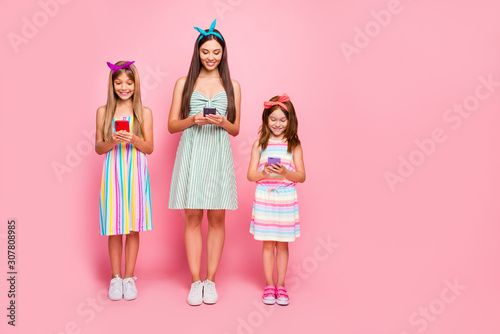 Full length photo of interested ladies with blonde brunette haircut having headbands use gadget wear skirt dress isolated over pink background