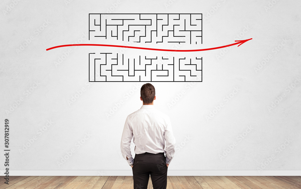 Businessman in doubt looking to a maze and searching the way out Businessman in doubt looking to a maze and searching the way out