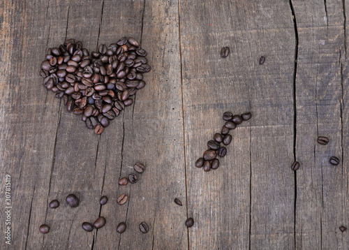heart shaped in coffee beans on a rustic plank background