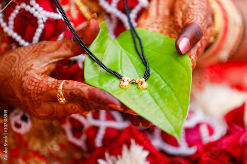 Traditional indian wedding ceremony : Mangalsutra with green leaf holding in hand  photo