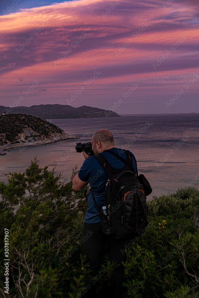 Man taking a photos with dslr camera outdoors, on the beach.