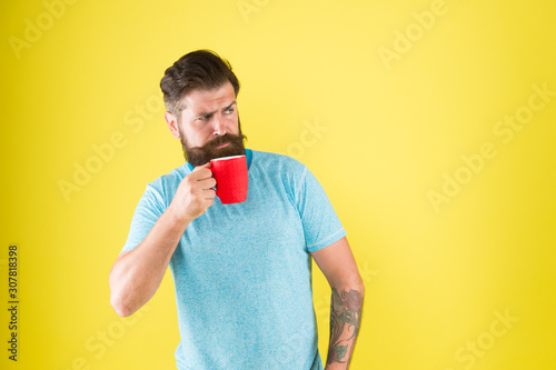 Morning habits lifestyle. Fanatic of coffee culture. Energy concept. Hipster barista yellow background. Coffee shop. Bearded man drink morning coffee. Tea time. Coffee with right proportion of milk