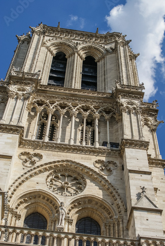 Close up of one of the towers of the Notre dame in Paris on a summer day with some clouds, France