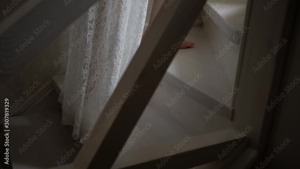 Girl in a white robe climbs the wooden stairs Girl in a white robe climbs the wooden stairs