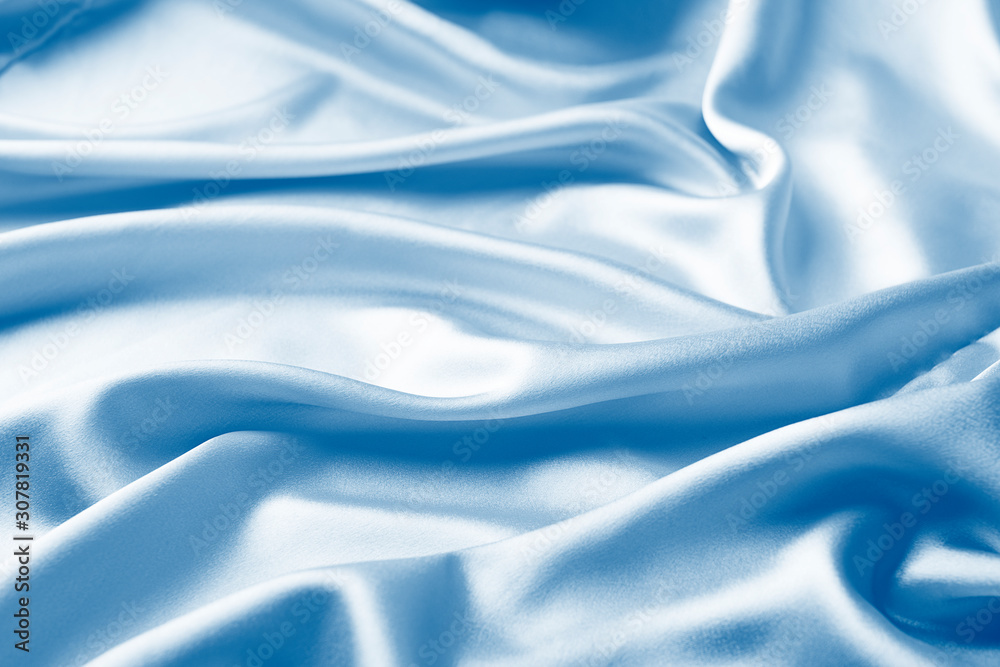 Fototapeta premium Background in satin pink fabric draped in classic blue waves. Trend monochrome tinting. Copy space of horizontal frame.