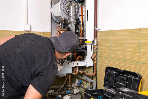 plumber fixing central heating system, Worker servicing a gas boiler