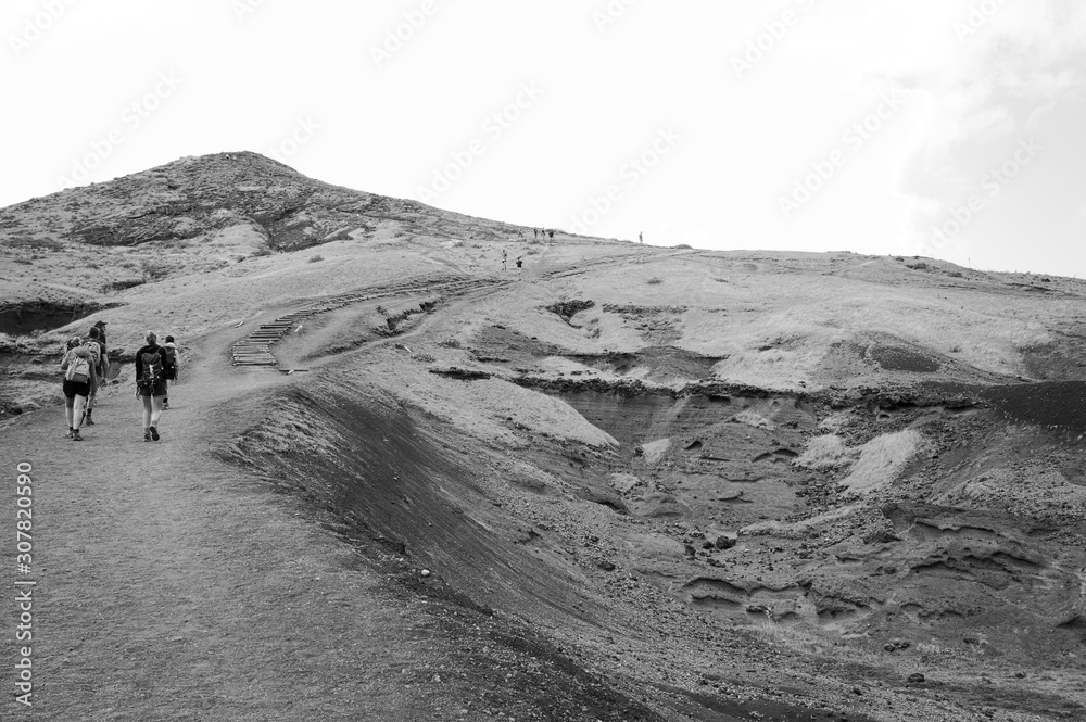 A group of hikers are walking along a desert pathway with volcanic rocks and sand dunes in Madeira Island (Ponta de Sao Lourenco, Portugal, Europe) A group of hikers are walking along a desert pathway with volcanic rocks and sand dunes in Madeira Island (Ponta de Sao Lourenco, Portugal, Europe)