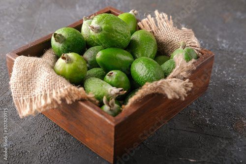 Feijoa fruit in a wooden plate on the table.