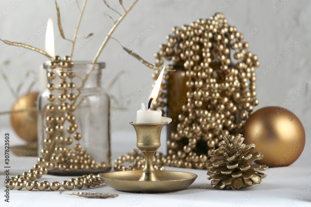 Golden Christmas decoration. Candle,  balls, cones and garland indoor..