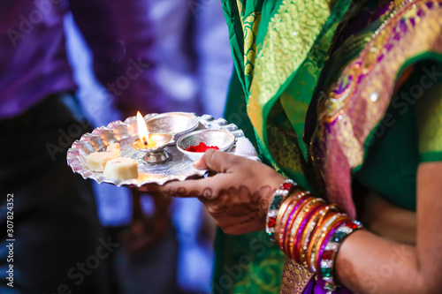 Holding puja thali and oil lamp in hand