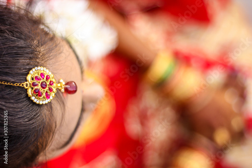 Indian bridal showing wedding hair style and head jewelry  photo