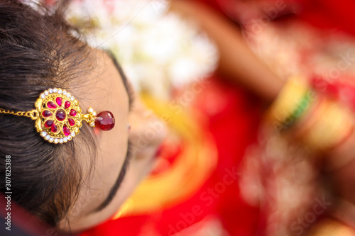 Indian bridal showing wedding hair style and head jewelry  photo