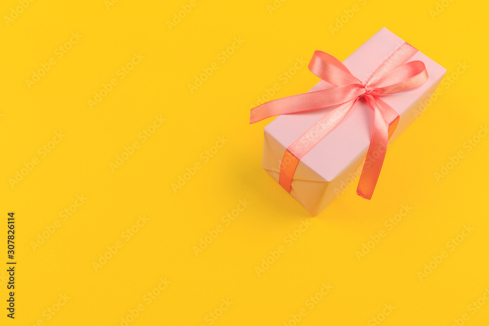 Gift box with ribbon and bow on color background and space for text. Top view - Image Gift box with ribbon and bow on color background and space for text. Top view - Image