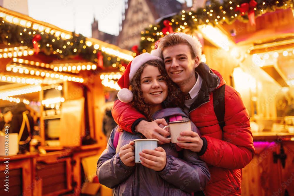 Young couple with drinks on Christmas market in Wroclaw, Poland