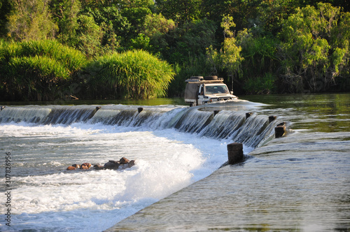 Offroad truck driving the Ivanhoe Crossing, Kununurra, Western Australia, Australia. A concrete causeway over Ord River. photo