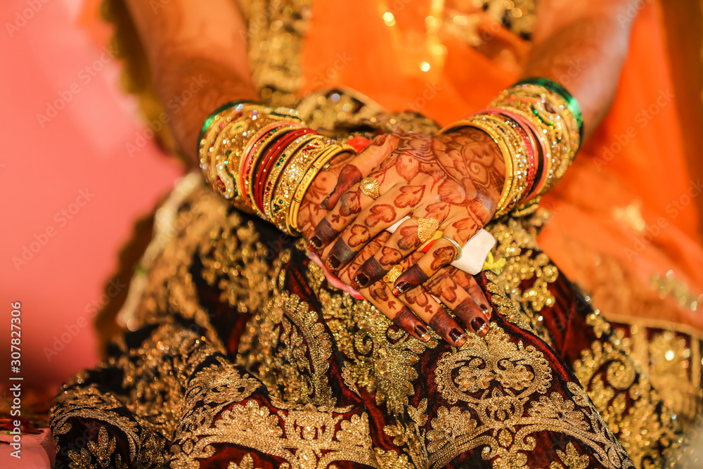 Fototapeta premium Beautiful Indian bride hand with mehandi design and jewelry