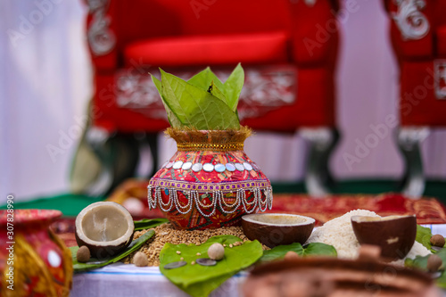 Indian wedding ceremony : decorative coper kalash with green leaf and coconut  photo