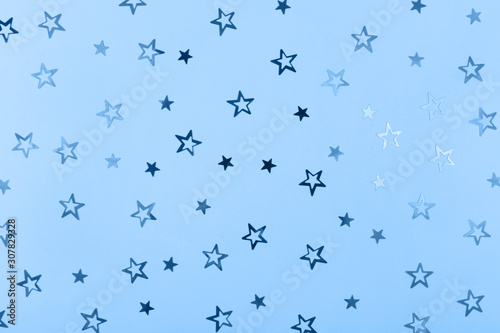 Festive background. Stars confetti on blue paper. Main color trend for 2020 year.
