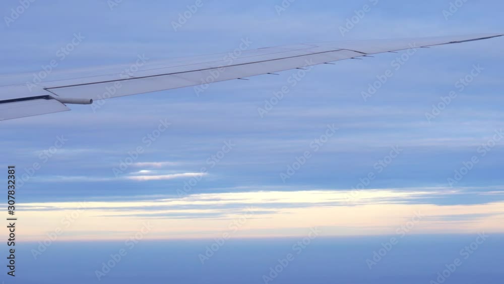 Cinematic aerial view of an airplane wing in the air at sunset time. Cinematic aerial view of an airplane wing in the air at sunset time.