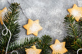 Chrismtas cookie stars and fir tree branches on gray background, holiday concept, top view, copy space