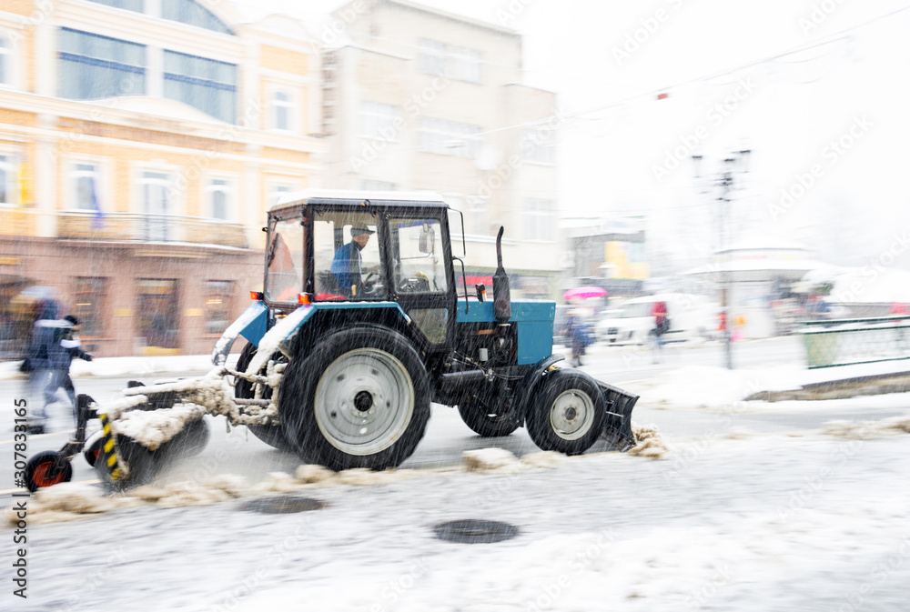 Snow removal machine cleaning the street from snow. Snowplow truck removing snow on the street after blizzard