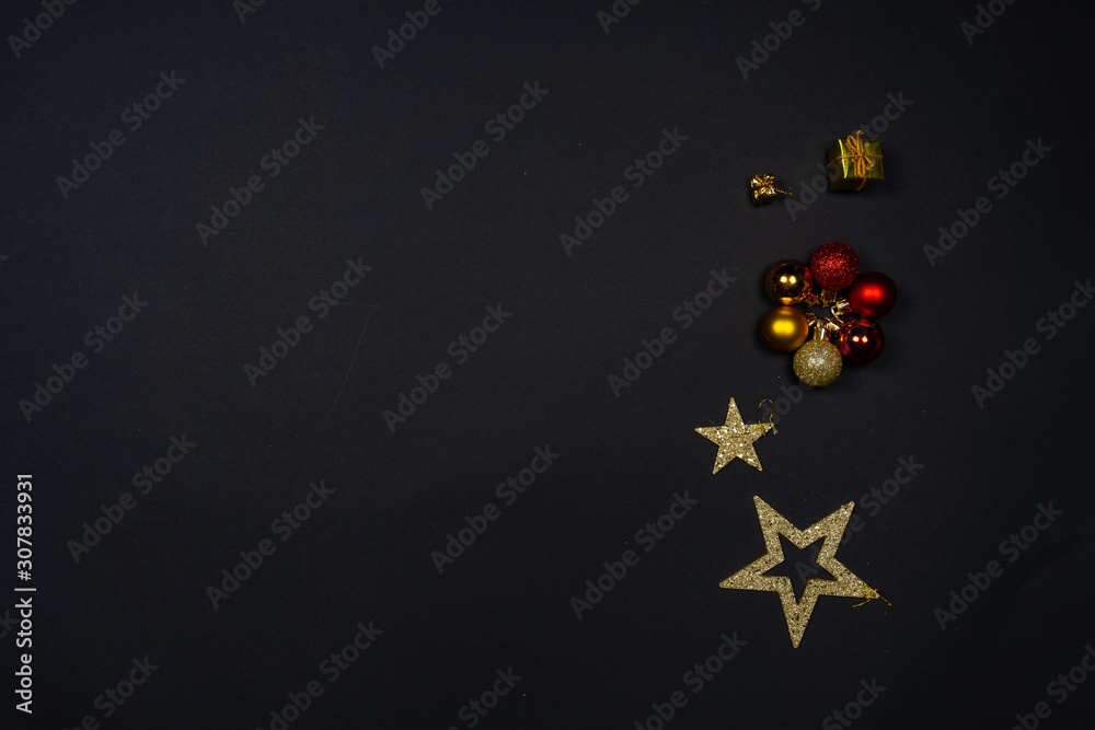 Fototapeta premium Christmas ornaments (Christmas baubles, stars and little presents) on black background