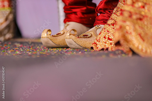 Traditional indian wedding ceremony : Groom puts on  wedding shoes photo