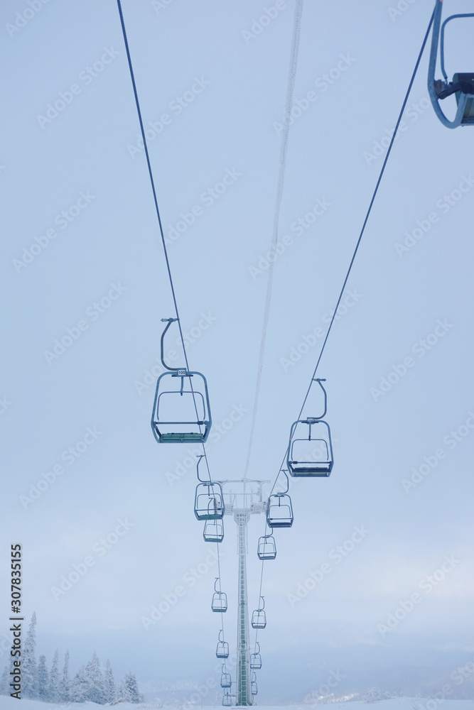 Winter landscape in Sheregesh. Funicular for tourists, skiers and snowboarders. lift to transport people in the mountains. the cable car on the background of blue mountains. funicular in the mountains Winter landscape in Sheregesh. Funicular for tourists, skiers and snowboarders. lift to transport people in the mountains. the cable car on the background of blue mountains. funicular in the mountains