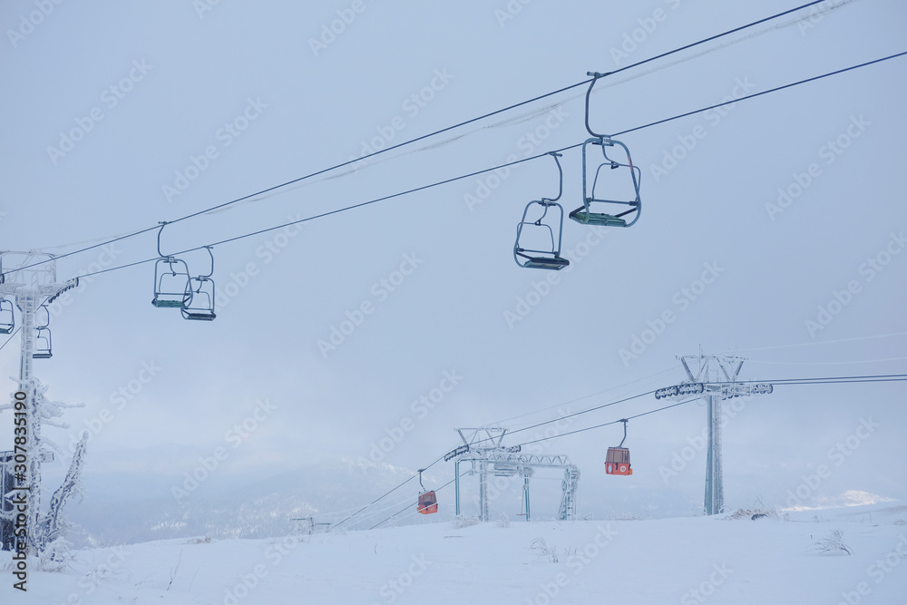 Winter landscape in Sheregesh. Funicular for tourists, skiers and snowboarders. lift to transport people in the mountains. the cable car on the background of blue mountains. funicular in the mountains Winter landscape in Sheregesh. Funicular for tourists, skiers and snowboarders. lift to transport people in the mountains. the cable car on the background of blue mountains. funicular in the mountains
