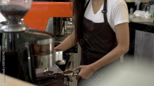 Batista beautiful young asian woman happily working at a coffee shop. She looked at the camera and smiling.