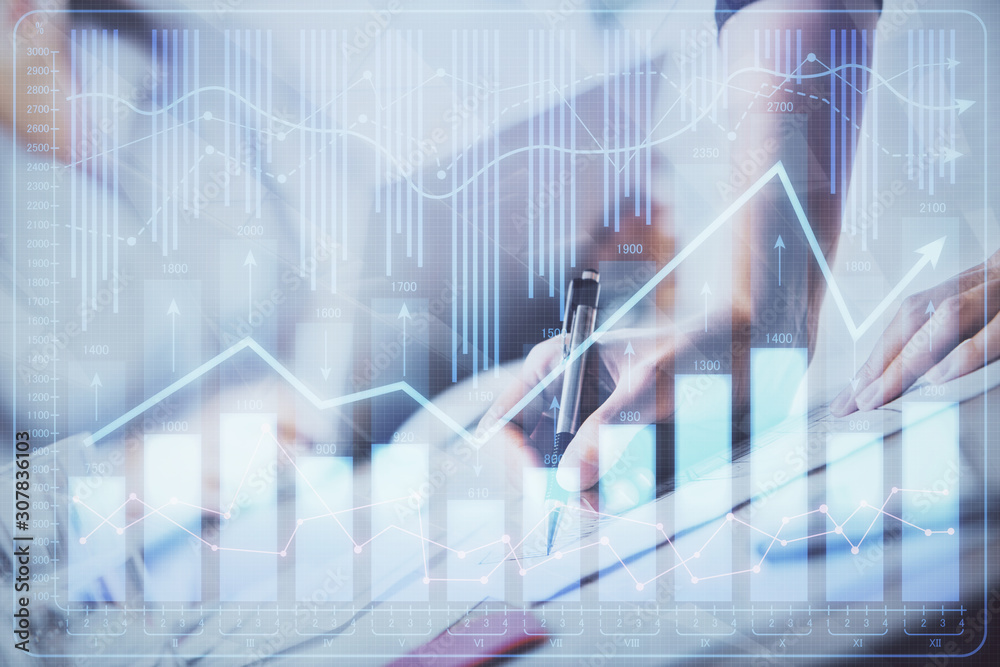 A woman hands writing information about stock market in notepad. Forex chart holograms in front. Concept of research. Double exposure A woman hands writing information about stock market in notepad. Forex chart holograms in front. Concept of research. Double exposure
