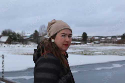 Portrait of a young woman in winter by the river