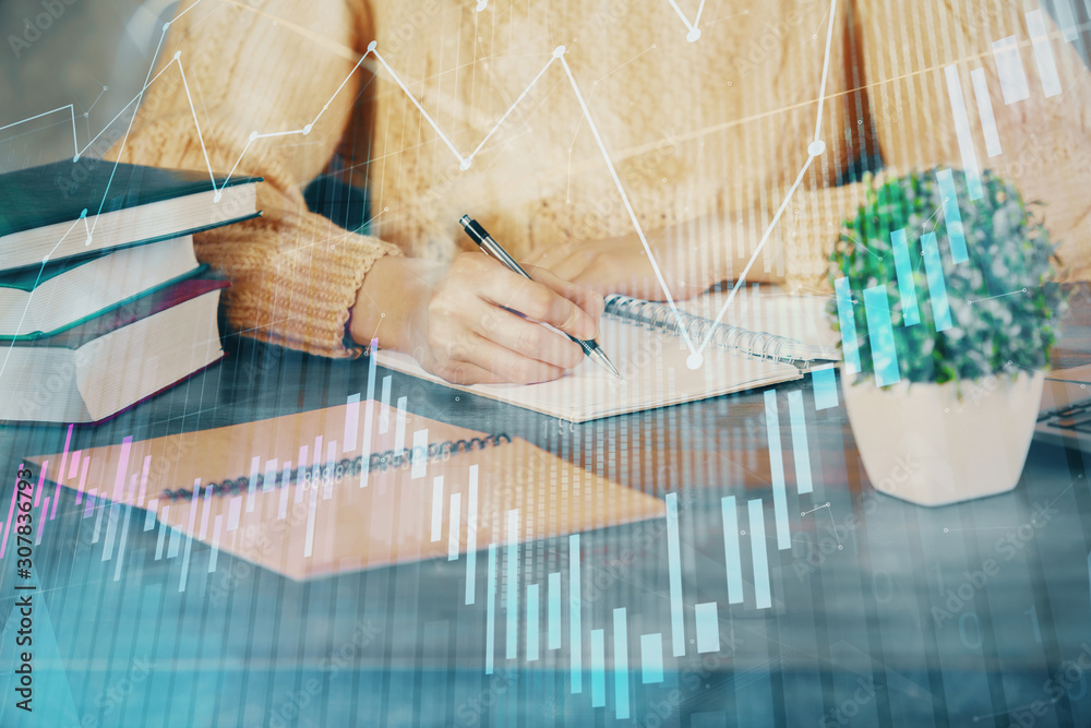 Forex graph on hand taking notes background. Concept of research. Double exposure Forex graph on hand taking notes background. Concept of research. Double exposure