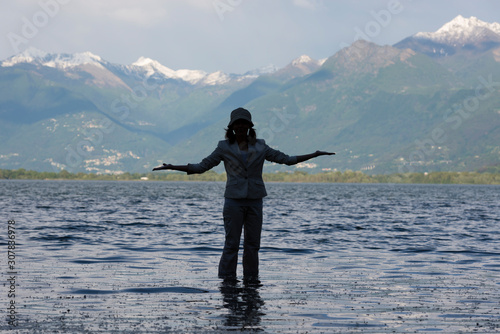 Woman Standing in a Flooding Alpine Lake with Mountain in Switzerland.