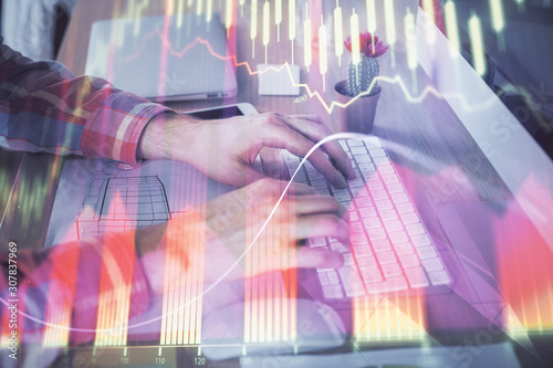 Double exposure of stock market chart with man working on computer on background. Concept of financial analysis. © peshkova