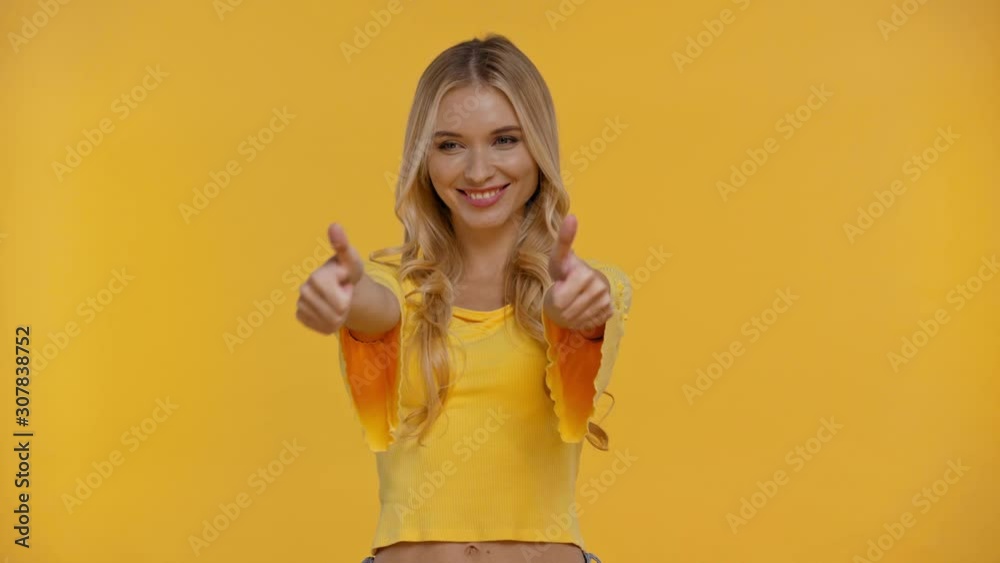 woman pointing with finger, showing likes isolated in yellow woman pointing with finger, showing likes isolated in yellow