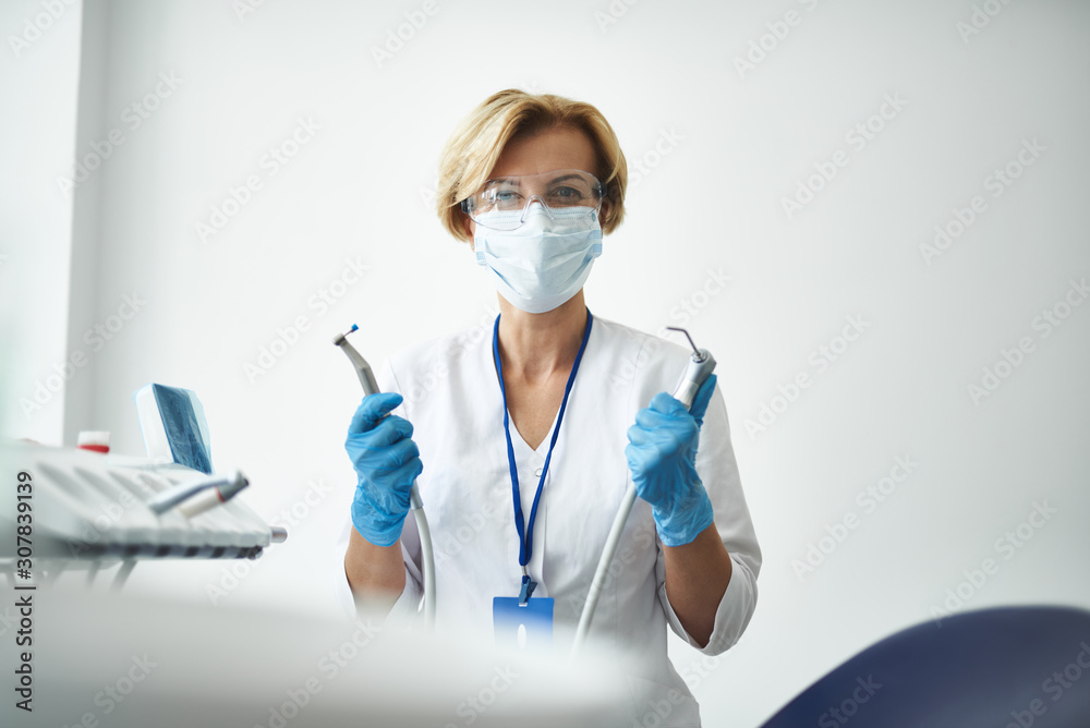 Waist up of a nice stomatologist enjoying her work Waist up of a nice stomatologist enjoying her work