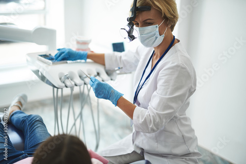 Dentist is using instruments during patient visit