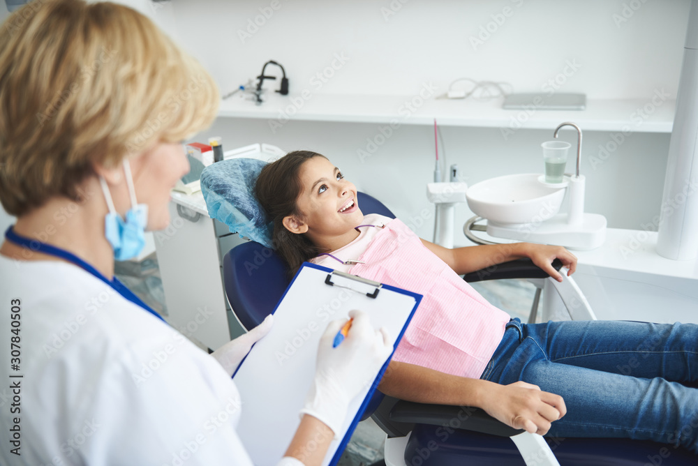 Teenage lady is happy after teeth check-up in clinic Teenage lady is happy after teeth check-up in clinic