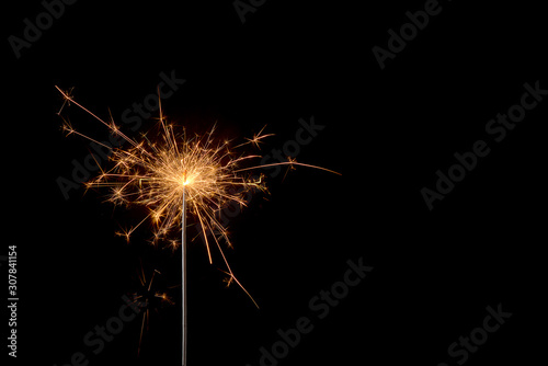 burning sparkler on a black background © Juri