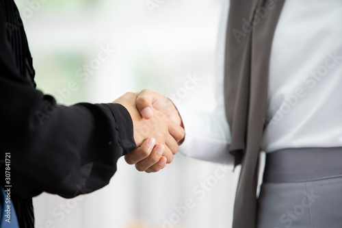 Beautiful Asian Muslim businesswoman handshake with her colleague close up.