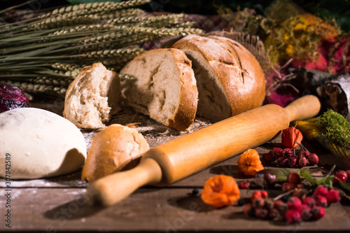 Baking bread with wheat flour and ears on table rystic background in bakery photo