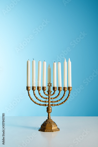 candles in menorah on blue background