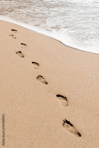 footprints in the sand with wave