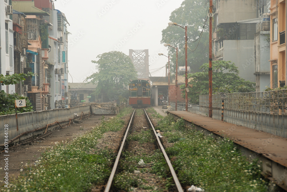 A train going from Train Street on Long Bien Bridge in Hanoi, Vietnam 