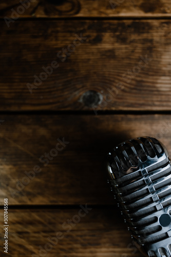 Retro microphone on dark wooden background with copy space for text