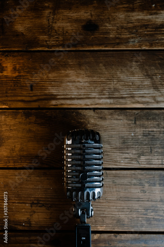 Retro microphone on dark wooden background with copy space for text. Vertical