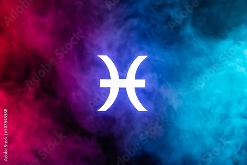 blue illuminated Pisces zodiac sign with colorful smoke on background