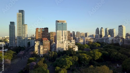 Aerial rising flying over Palermo Woods revealing Buenos Aires buildings. DOLLY IN photo