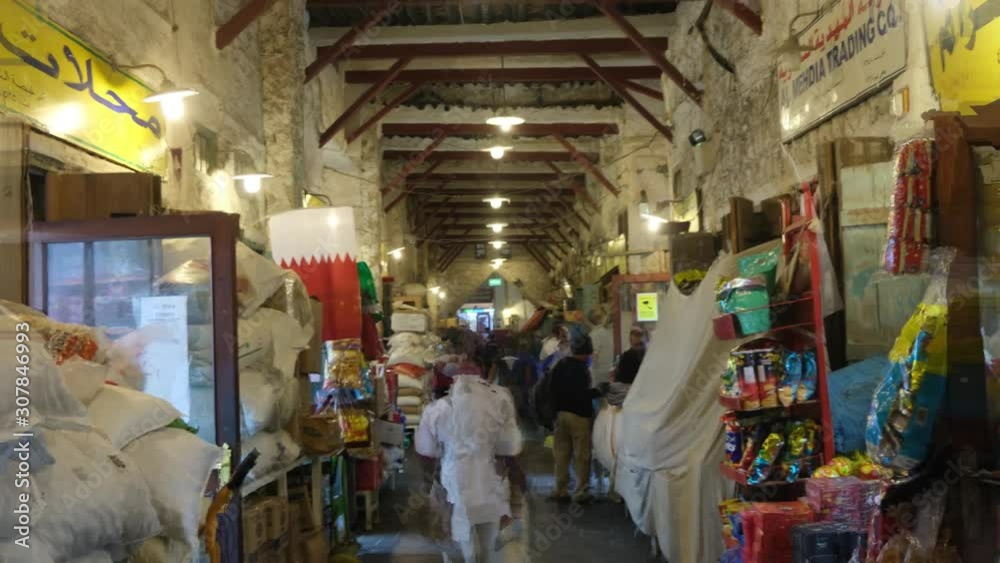 DOHA, QATAR- November 2019 Hyperlapse Crowd of people at Souq Waqif or the standing market. Qatar flag in shot